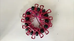 Closeup detail of the outdoor elastic clothesline showing pink clips and black beads.