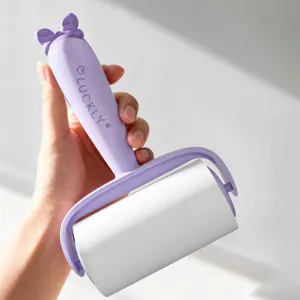 Handheld purple lint roller with cute bow handle, tearable sticky brush for clothes and pet hair.