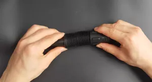 Vista detallada de manguera corrugada flexible negra, tubo de extensión de plástico duradero.