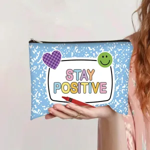 Close-up of Stay Positive printed blue canvas pouch with smiley face and heart details.