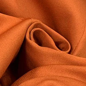 Détail de texture de tissu de costume orange, gros plan de matériel tissé pour tenue pro.