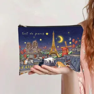 Hand holding a vintage cosmetic bag with Paris night sky oil painting print.
