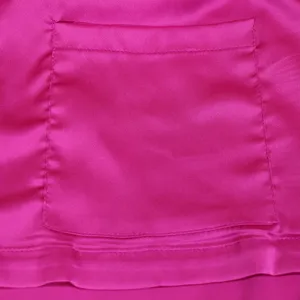 Close up detail of vibrant pink satin pocket and hem stitching, smooth fabric texture.
