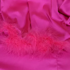 Detailed shot of hot pink satin fabric with matching fluffy feather trim, elegant texture.