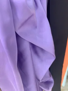Purple satin dress fabric detail close-up showcasing smooth texture and soft natural folds.