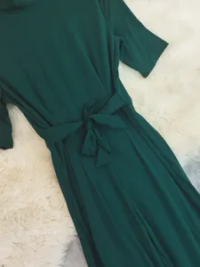 Dark green short-sleeve wide-leg jumpsuit detail featuring a chic waist bow and lapel design.