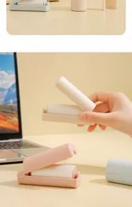 Portable foldable mini lint roller for clothes and pet hair removal with tearable sticky sheets.