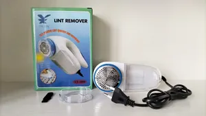 Electric lint remover detail view showcasing the plug-in fabric shaver, box, and cleaning brush.
