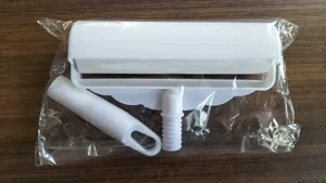 Lint roller detail view showing white plastic sticky brush components neatly in clear packaging.