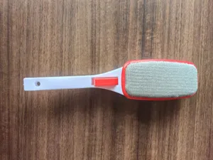 Dettaglio ravvicinato della testina della spazzola levapelucchi rotante con tessuto grigio resistente.