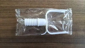 White plastic component with ribbed plug and U-shaped handle, packaged in clear bag.