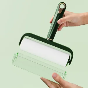 Detailed view of green lint roller with sticky paper roll and dust cover for easy home cleaning.