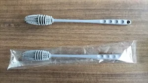 Detail view of grey silicone long handle bottle brush with dense bristles and hanging hole.