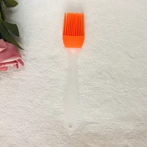 Vista detallada del pincel de cocina de silicona con cerdas anaranjadas y mango transparente.