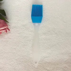 Vista detallada de una brocha de silicona azul para repostería y utensilios de barbacoa.