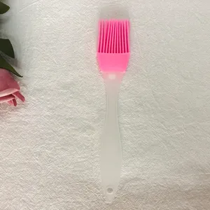 Vista detallada de la brocha de repostería de silicona rosa con mango transparente para cocina.