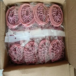 Detail view of pink spiral drying racks with multiple clips packed securely inside a cardboard box.