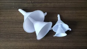 Close-up detail view of white plastic funnels set, showing nested design and hanging holes.