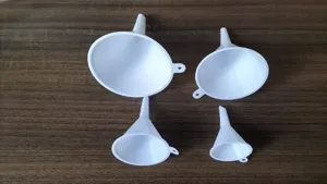 Close-up detail shot of white plastic funnels set in various sizes for kitchen and home use.