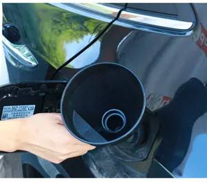 Vista detallada del embudo de combustible de plástico negro con filtro insertado en el depósito.