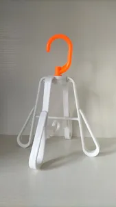 Detail shot of the foldable plastic shoe drying rack showing the orange hook and structure.