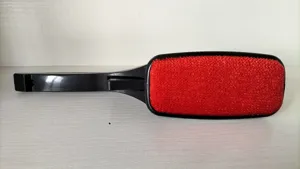 Vista dettagliata della spazzola levapelucchi nera e rossa per vestiti e divani.