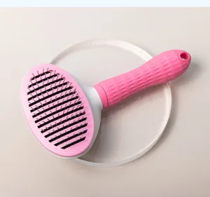 Pet slicker brush detail shot showcasing pink ergonomic handle and fine stainless steel pins.