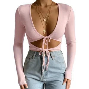 Pink ribbed long sleeve crop top with deep V-neck, front tie cutout, stretchy tight fit.