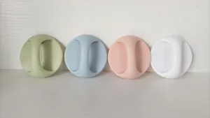 Close-up detail of four pastel round adhesive cabinet door handles in green, blue, pink, white.