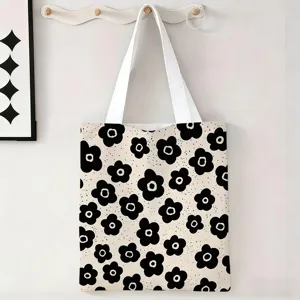 Detalle de bolsa de lona con estampado floral negro colgada en un gancho de pared