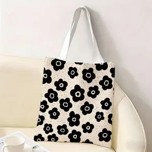 Vista detalle de bolsa tote de lona con estampado floral en blanco y negro sobre sofá