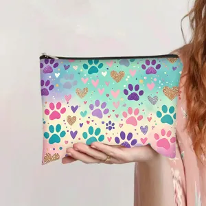 Vibrant watercolor gradient cosmetic pouch with paw and heart print held in hand