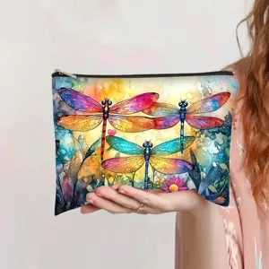 Detailed view of dreamy watercolor dragonfly print on a canvas makeup pouch held in hand