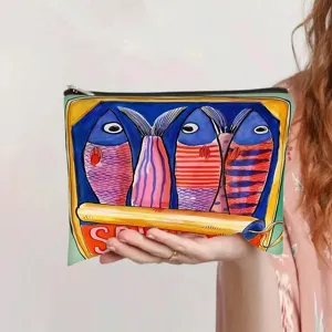 Close-up of watercolor sardine can fish print canvas makeup pouch held by model.