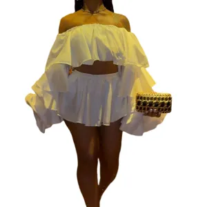 Detailed view of the stylish off-shoulder ruffled top and mini skirt two-piece set in white.