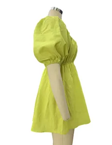 Side view detail of the solid yellow-green puff sleeve mini dress, showing waist and sleeve.