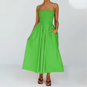 Close-up view of the vibrant green summer spaghetti strap smocked midi dress with pockets.