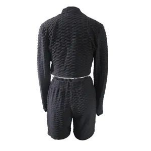 Black textured two-piece activewear set featuring a long sleeve crop top and matching shorts.