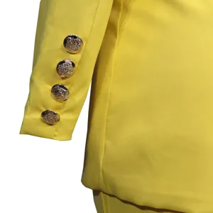 Gelbes Damen Blazer Ärmel Detail mit vier verzierten goldenen Metallknöpfen stilvoll.