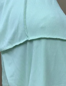Close-up detail of light green ribbed fabric and neat stitching for women summer jumpsuit.