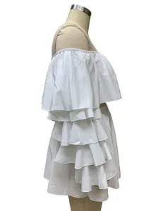 Side detail of white off-the-shoulder layered ruffle top and mini skirt two-piece set.