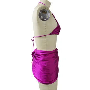 Dettaglio laterale set bikini magenta, top halter monocolore e gonna sarong per spiaggia.