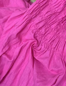 Hot pink linen blend dress detail showcasing elastic smocked bodice and soft fabric texture