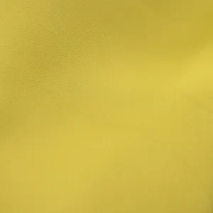 Einfarbig gelber Stoffdetail für Anzüge, hochwertige Textur für Damenbekleidung.