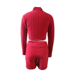 Red women activewear two piece set, long sleeve crop top and shorts, textured gym outfit.