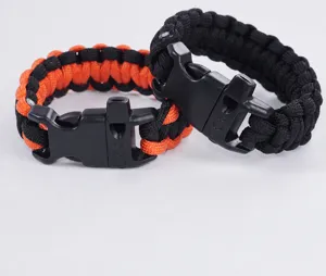 Paracord bracelet detail showing black and orange survival whistle buckle design.