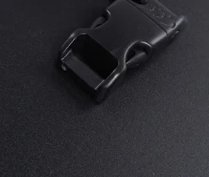 Detail shot of black plastic side release buckle with integrated whistle for paracord bracelets.