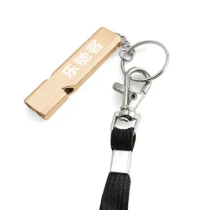 Gold metal emergency whistle with black lanyard and key ring for outdoor survival use.