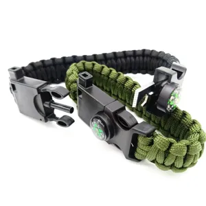 Detail shot of survival paracord bracelet with compass, whistle and fire starter tools.
