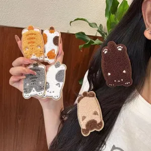 Plush cartoon cat hair patches worn on model's dark hair showing texture and detail